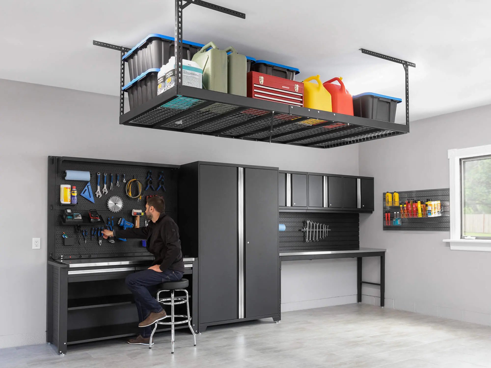 man seated at storage cabinets with overhead rack above
