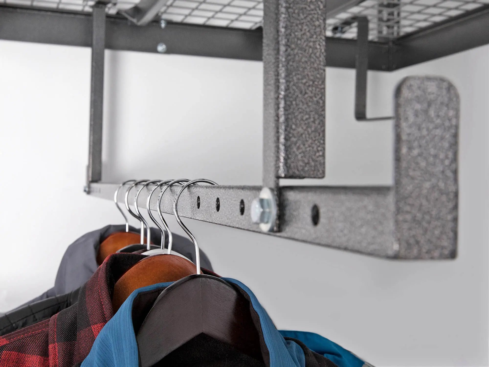 shirts hanging on bar under ceiling mounted storage solution