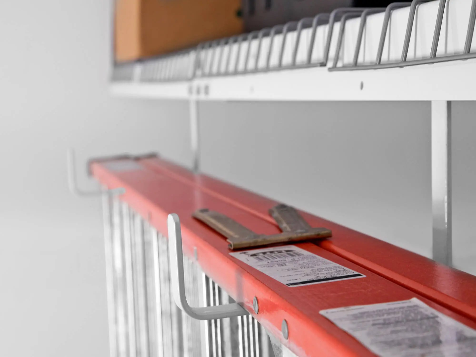 ladder stored on hooks in garage