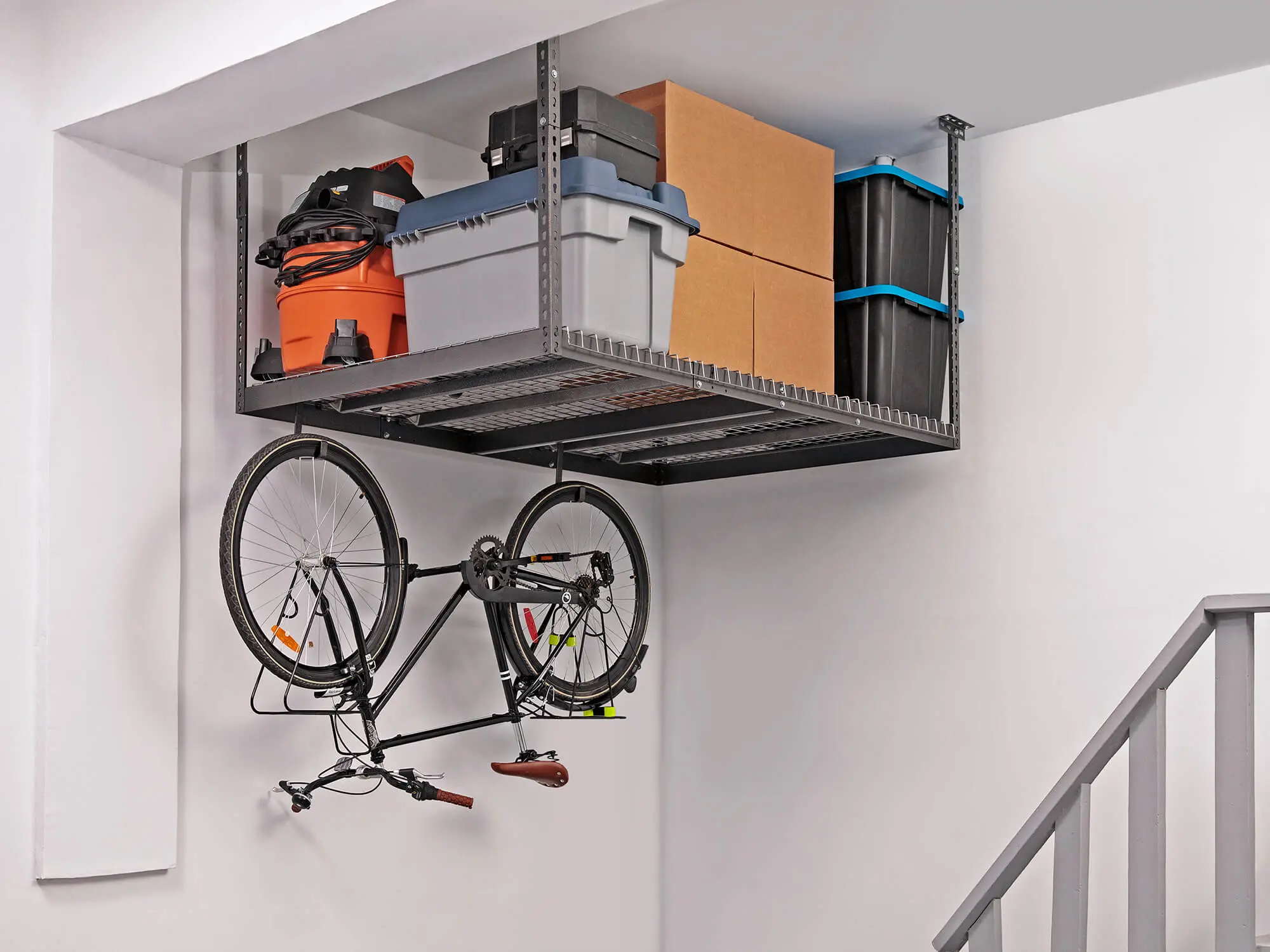overhead storage rack full with items and bike hanging below