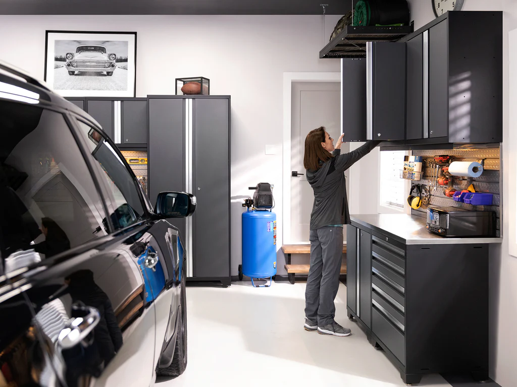 Woman reaching for item in high-end black garage cabinets