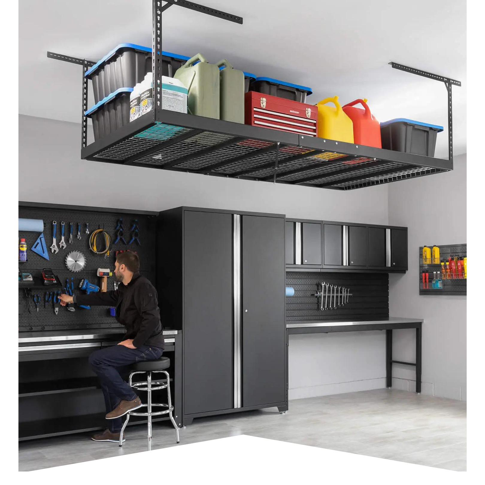 man seated in pristine garage with black cabinets and overhead storage